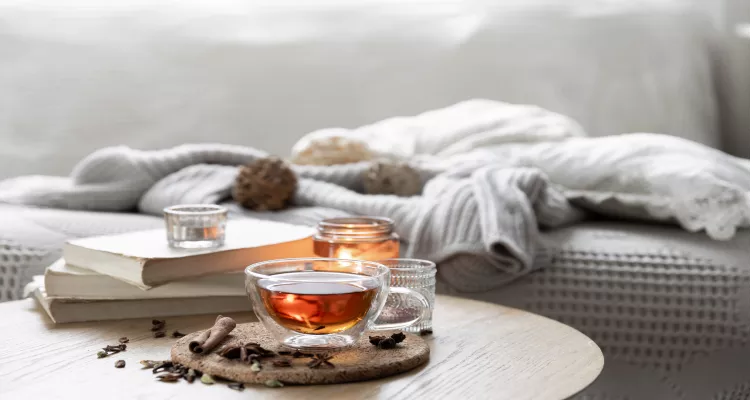 A cozy setup with a steaming mug of honey and cinnamon tea, perfect for soothing sore throats