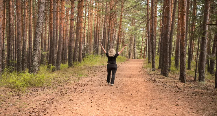 Person earthing on a forest path for energy and natural health