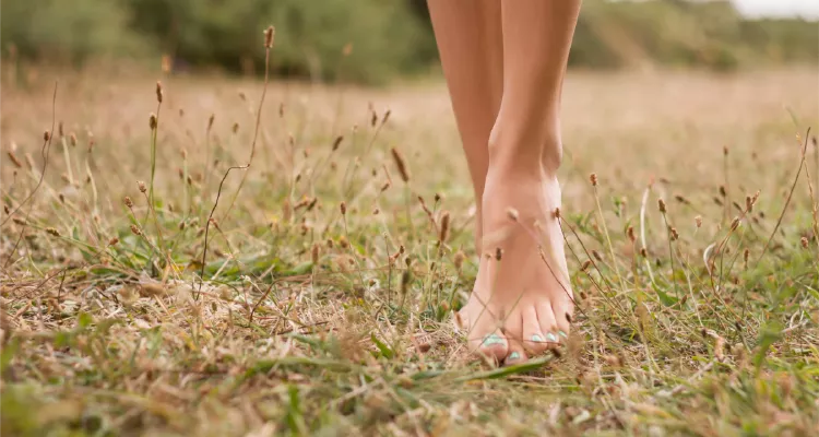 Person practicing earthing on grass for natural health benefits